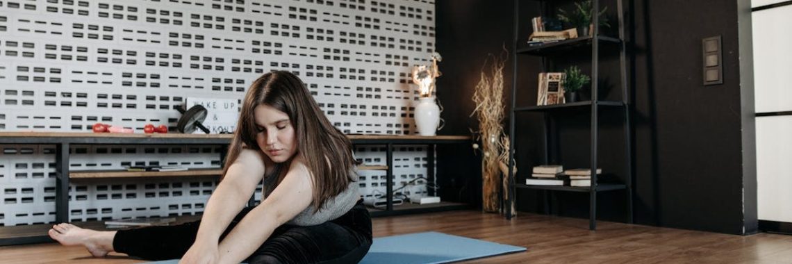 Woman practicing yoga stretch on mat in modern home interior. Promotes wellness and flexibility.