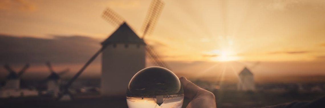 Sunset view of historic windmills through a crystal ball in Campo de Criptana, Spain.